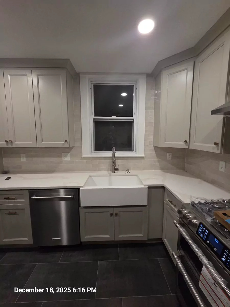 Completed kitchen remodel showing cabinets, counters, lighting, and appliances in Aurora
